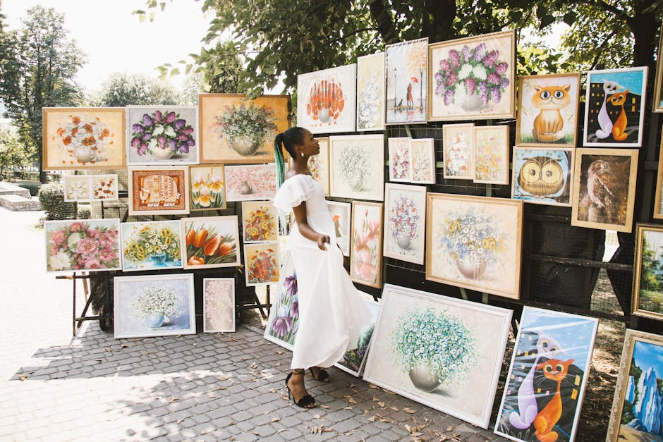 pexels-photo-1321552-1321552 A woman admires various colorful artworks displayed in an outdoor street exhibition.