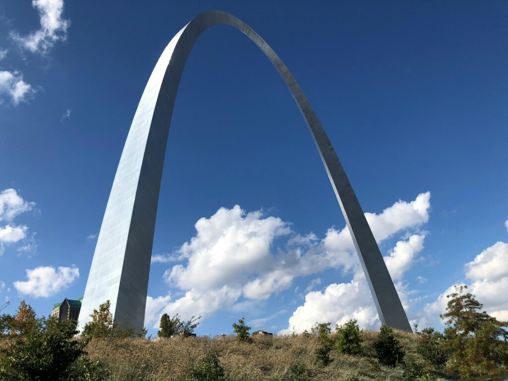 pexels-photo-20806164-20806164 Stunning view of the Gateway Arch in St. Louis, Missouri, against a bright blue sky with clouds.