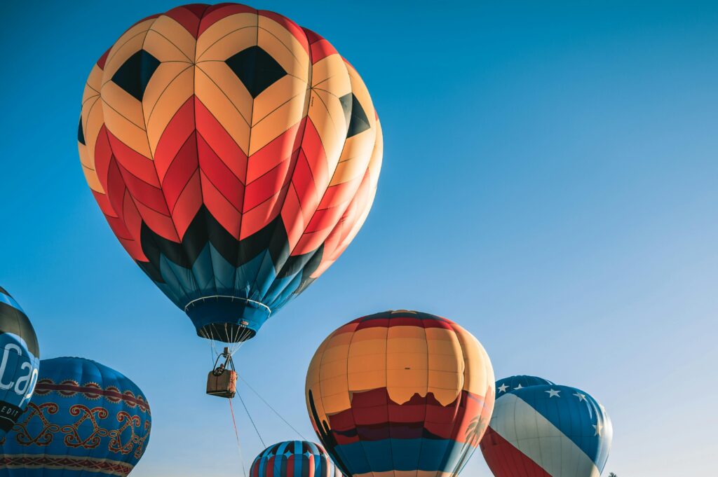 pexels-photo-3027218-3027218 Colorful hot air balloons floating in a clear blue sky, perfect for travel enthusiasts.