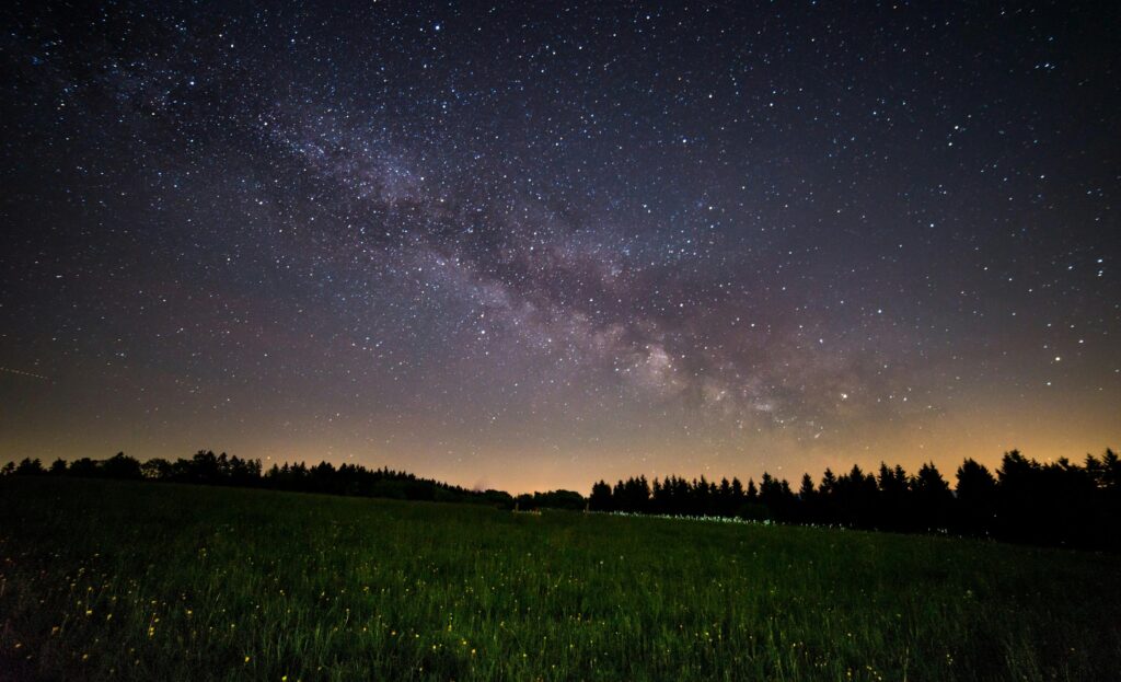 pexels-photo-433155-433155 A breathtaking view of a starry night sky over a quiet field, showcasing the Milky Way.
