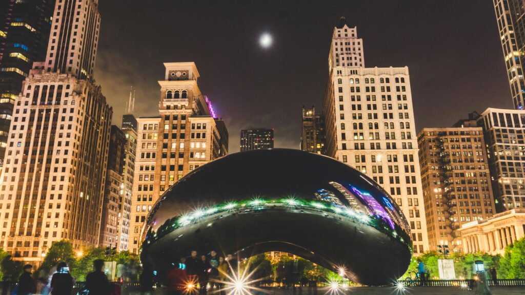 pexels-photo-2093318-2093318 Illuminated Cloud Gate with Chicago skyline at night, featuring reflections and urban charm.