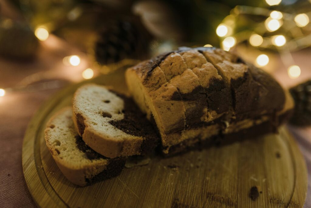 Delicious marbled cake slices on a festive wooden cutting board with warm holiday lights.